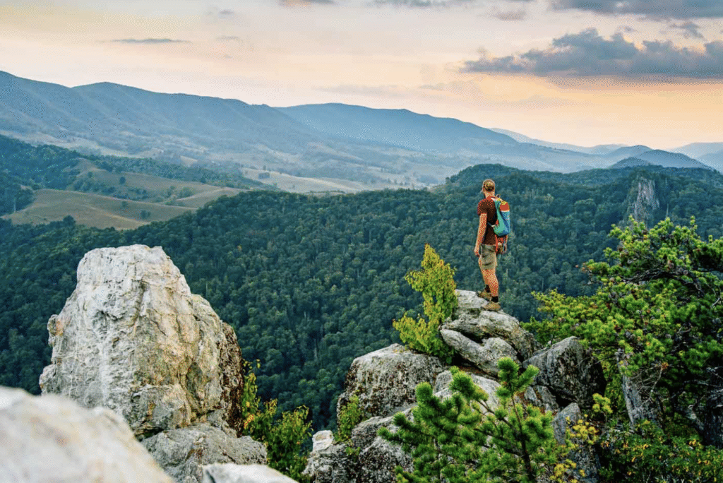 Man standing on a rock overlooking mountains